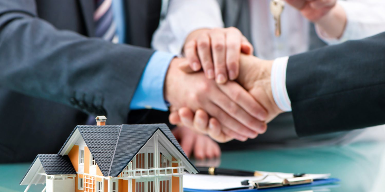 Estate agent shaking hands with customer after contract signature